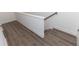 Hallway features sleek hardwood floors leading to a staircase with white trim and gray walls at 506 Healy Dr # 74, Cumming, GA 30040