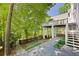 Home's backyard features a large deck, stairs to the ground, and stone walkway and fence at 55 Bransford Rd, Sandy Springs, GA 30324