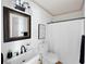 Bathroom features a white sink, dark faucet, toilet, mirror and tub/shower combo with a white shower curtain at 55 Bransford Rd, Sandy Springs, GA 30324