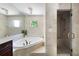 Spa-like bathroom featuring a soaking tub and glass-enclosed shower at 55 Bransford Rd, Sandy Springs, GA 30324
