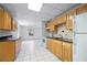 Kitchen with light wood cabinetry, black granite countertops, and white appliances at 55 Bransford Rd, Sandy Springs, GA 30324