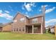 Spacious backyard view of a brown home with a covered back porch area at 651 Deer Springs Way, Loganville, GA 30052