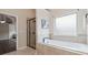 Bright bathroom featuring a luxurious soaking tub and a separate glass-enclosed shower at 651 Deer Springs Way, Loganville, GA 30052