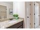 Well-lit bathroom featuring a granite countertop, decorative mirror, and white doors at 651 Deer Springs Way, Loganville, GA 30052