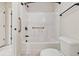 Clean, bright bathroom features a white shower-tub combo, grab bars, and neutral tile at 651 Deer Springs Way, Loganville, GA 30052
