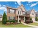 Inviting two-story home with a covered front porch, lush landscaping, and a charming neighborhood ambiance at 651 Deer Springs Way, Loganville, GA 30052