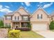 Charming two-story home featuring a two-car garage, landscaped yard, and welcoming front porch at 651 Deer Springs Way, Loganville, GA 30052