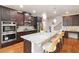 Gourmet kitchen with granite countertops, stainless steel appliances, large island and modern pendant lighting at 651 Deer Springs Way, Loganville, GA 30052