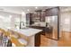 Kitchen featuring a large island, granite countertops, stainless steel refrigerator, and dark wood cabinets at 651 Deer Springs Way, Loganville, GA 30052