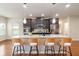 Spacious kitchen boasts a large island with seating, granite countertops, stainless appliances, and dark cabinets at 651 Deer Springs Way, Loganville, GA 30052