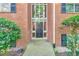 Exterior view of building entrance with brick facade, decorative shrubbery, and black window shutters at 1111 Clairemont Ave # N3, Decatur, GA 30030
