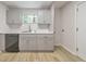 Updated kitchen featuring a stainless steel dishwasher, white cabinets, and wood look vinyl flooring at 1111 Clairemont Ave # N3, Decatur, GA 30030