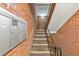 Interior staircase features brick walls, carpeted steps and black metal handrails, leading upwards at 1111 Clairemont Ave # N3, Decatur, GA 30030