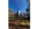 Back of a two-story house with gray siding, deck, walkout basement, and sloped backyard with trees at 192 Paces Lakes Pt, Dallas, GA 30157