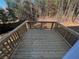 A wooden deck with railings overlooks a lush, wooded backyard offering a serene outdoor space at 192 Paces Lakes Pt, Dallas, GA 30157