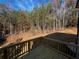 Corner view from the deck overlooking the backyard trees with wooden railing and wood plank flooring at 192 Paces Lakes Pt, Dallas, GA 30157