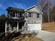 Charming two-story home with gray siding, brick accents, a covered porch, and a two-car garage at 192 Paces Lakes Pt, Dallas, GA 30157