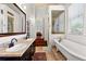 Bathroom showcasing double sinks with a vanity and a clear view into the soaking tub at 429 Oakland Ave, Atlanta, GA 30312