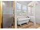 Bright bathroom featuring a soaking tub next to shower with natural light pouring through the window at 429 Oakland Ave, Atlanta, GA 30312