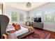 Bright bedroom featuring a plush bed, hardwood floors, large windows, and stylish furnishings at 429 Oakland Ave, Atlanta, GA 30312