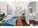 Elegant hallway featuring hardwood floors, chandeliers, and a cozy blue settee at 429 Oakland Ave, Atlanta, GA 30312