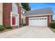 Traditional home featuring a red front door, brick accents, and a two-car garage at 2525 Highbrooke Trl, Duluth, GA 30097
