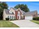 Charming traditional home featuring a red brick facade, manicured lawn, and attached two-car garage at 2525 Highbrooke Trl, Duluth, GA 30097