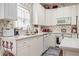 Cozy kitchen with white cabinets, appliances, and floral wallpaper, creating a warm, inviting atmosphere at 2525 Highbrooke Trl, Duluth, GA 30097