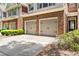 A close view of townhome garages with brick accents and a paved driveway at 2957 Smith Ridge Trce, Peachtree Corners, GA 30071
