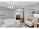 Spacious bedroom with an armchair, view into entry hall, and modern chandelier at 756 Joseph E Lowery Sw Blvd, Atlanta, GA 30310