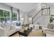 Bright living room with large windows, vaulted ceiling, and staircase to the second floor at 756 Joseph E Lowery Sw Blvd, Atlanta, GA 30310