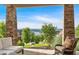 Covered patio with stone columns, comfortable seating, and picturesque views of the surrounding landscape and lake at 89 Somerset Ln, Cartersville, GA 30121