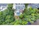 Aerial view of a backyard featuring a luxurious pool, spa, patio, and lush greenery near a lake at 965 Tiverton Ln, Alpharetta, GA 30022