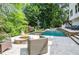 Backyard oasis features a luxurious pool, fire pit, and lounge area at 965 Tiverton Ln, Alpharetta, GA 30022