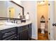 Bathroom featuring dark vanity with marble countertop and decorative mirror at 965 Tiverton Ln, Alpharetta, GA 30022