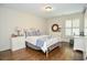 Bright bedroom featuring hardwood floors, a white metal bed frame, and neutral-toned decor at 965 Tiverton Ln, Alpharetta, GA 30022