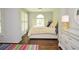 Comfortable bedroom featuring a shuttered window, sunny yellow bedding, and hardwood floors at 965 Tiverton Ln, Alpharetta, GA 30022