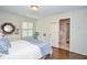 Bedroom with hardwood floors, shuttered window and white dresser, leading to bathroom at 965 Tiverton Ln, Alpharetta, GA 30022