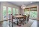Bright dining area features a wooden table, a modern light fixture and access to the deck at 965 Tiverton Ln, Alpharetta, GA 30022