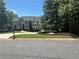 Stately two-story home with a well-manicured front lawn, mature trees, and a circular driveway at 965 Tiverton Ln, Alpharetta, GA 30022