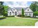 Elegant two-story home with manicured lawn, complemented by lush landscaping and a paved walkway at 965 Tiverton Ln, Alpharetta, GA 30022