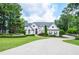 Stately white home with meticulously landscaped lawn and circular driveway at 965 Tiverton Ln, Alpharetta, GA 30022