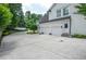 Spacious three-car garage and driveway surrounded by landscaping and trees at 965 Tiverton Ln, Alpharetta, GA 30022