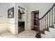 Elegant hallway with staircase featuring decorative wrought iron spindles and views into office space at 965 Tiverton Ln, Alpharetta, GA 30022