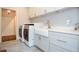 Bright laundry room with farmhouse sink, quartz countertops, and modern washer/dryer at 965 Tiverton Ln, Alpharetta, GA 30022