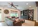 Living room features a dark brown leather sectional sofa, a ceiling fan and custom built-ins at 965 Tiverton Ln, Alpharetta, GA 30022