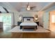 Cozy main bedroom with tray ceiling, ceiling fan, and natural light; an open door leads to the ensuite bathroom at 965 Tiverton Ln, Alpharetta, GA 30022