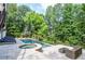 A beautiful backyard pool area with lounge chairs and an outdoor seating area, surrounded by lush greenery at 965 Tiverton Ln, Alpharetta, GA 30022