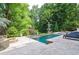 Serene backyard pool with lounge chairs and fire pit, surrounded by lush greenery for ultimate relaxation at 965 Tiverton Ln, Alpharetta, GA 30022