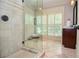 Walk-in shower with glass enclosure and stone tile in the bathroom at 965 Tiverton Ln, Alpharetta, GA 30022